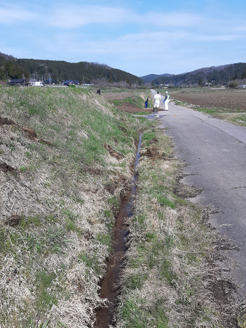 災害で人出不足となった農業地区での排水溝の泥上げ作業